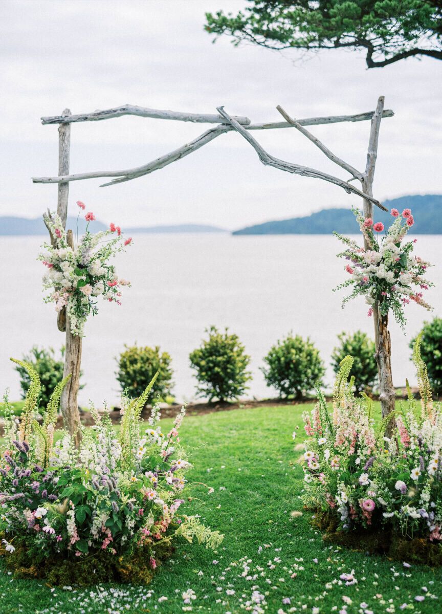 Wedding Venue: Private Residence, ceremony arch made of branches with floral accents, overlooking the ocean