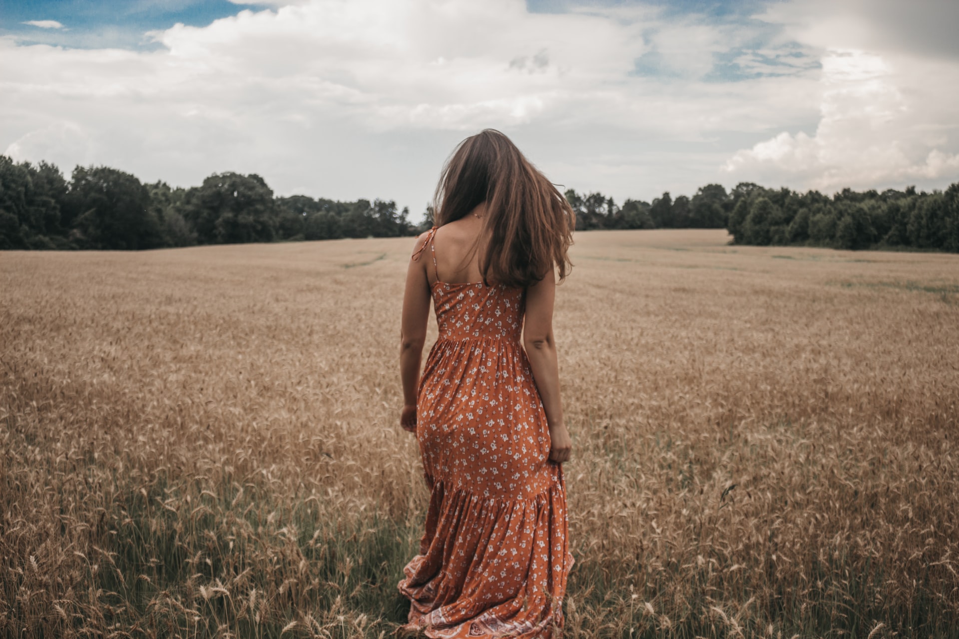 Pretty girl walking away in a field