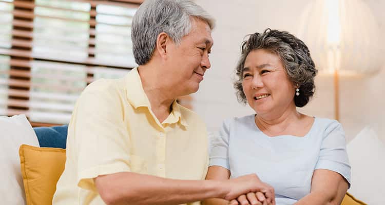asian elderly couple holding their hands while taking together living room couple feeling happy share support each other lying sofa home