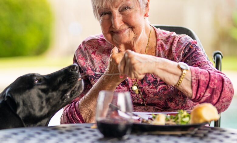Older woman on a date feeding a dog