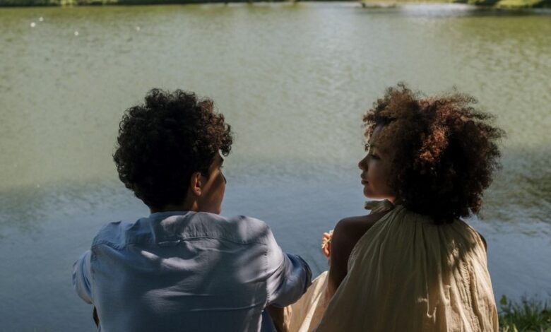 boy and girl sitting near a lake 1024x778