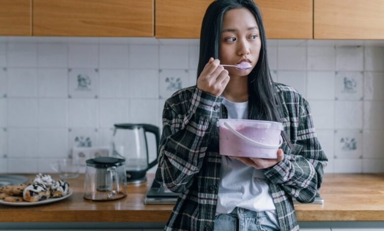 woman eating out of a bucket of ice cream depressed and sad 1024x683