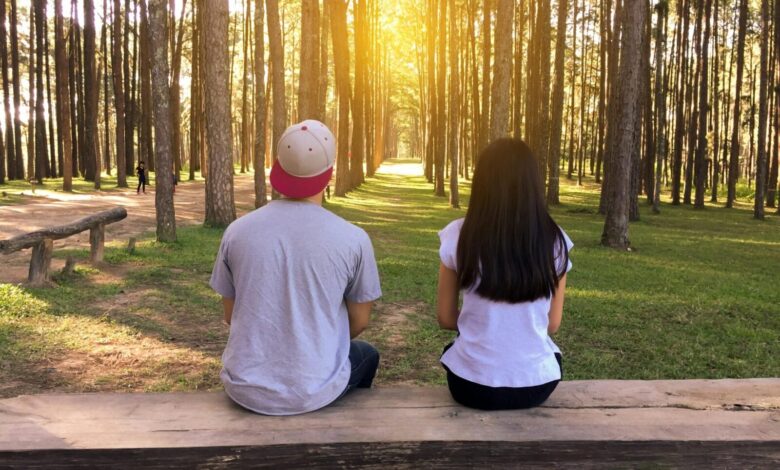 man and woman sitting on bench in woods stockpack pexels scaled e1722604819935